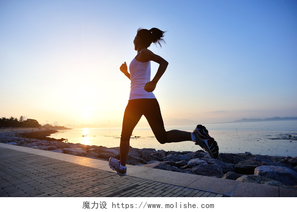 在海边跑步的女性运行在海边的跑步运动员。女人健身剪影日出慢跑锻炼健康概念.